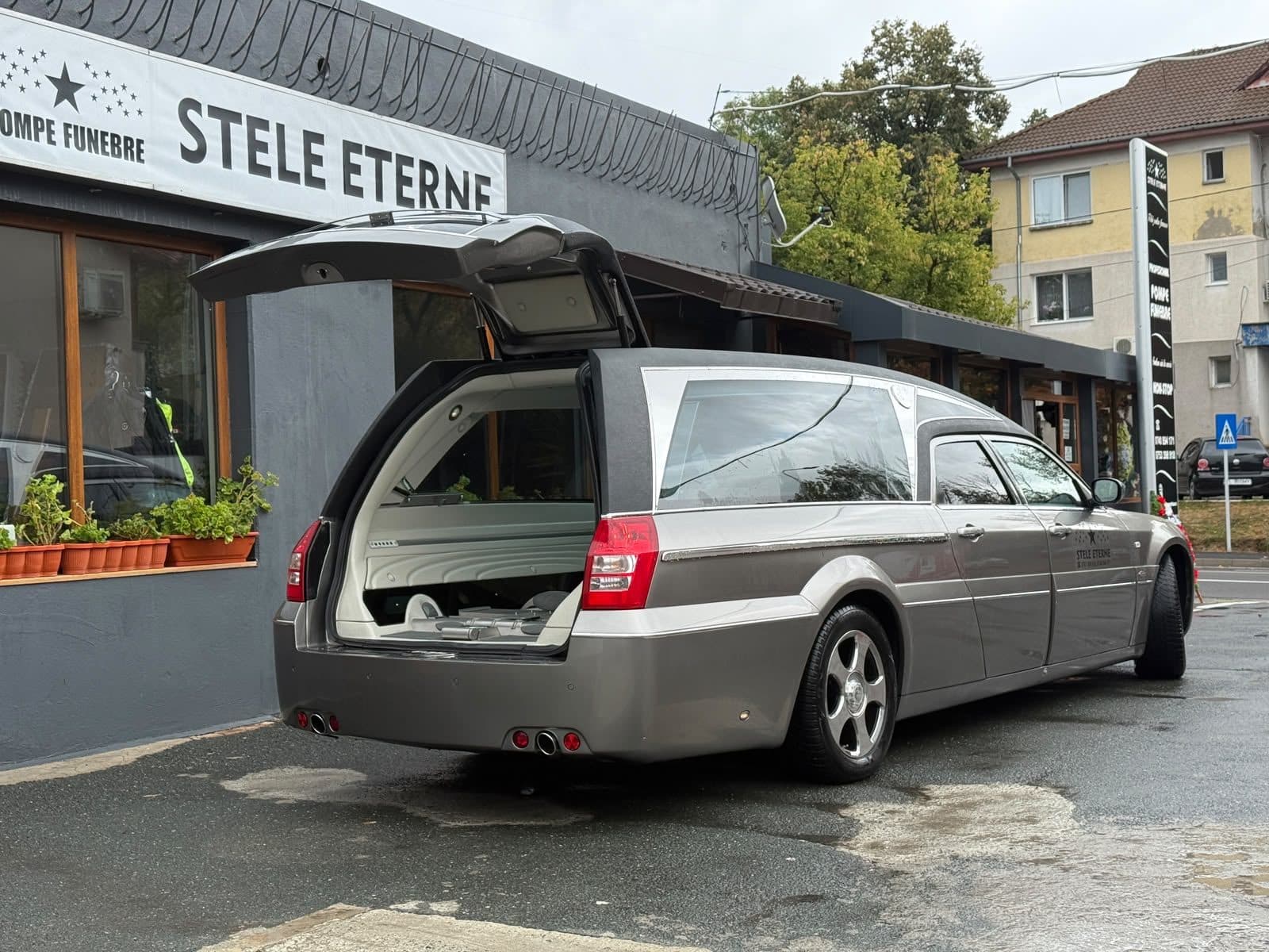 Autospeciala funerară cu hayonul deschis lângă agenția din Tulcea