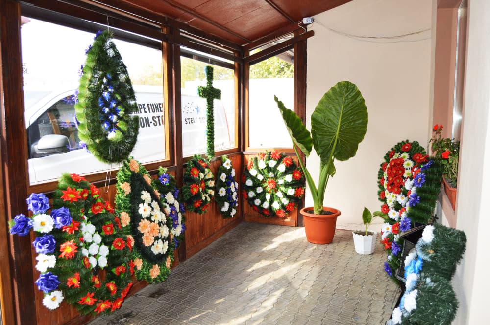 Coroane funerare expuse la intrarea în agenție